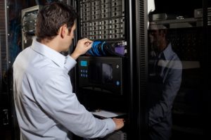 An IT technician works on a server network